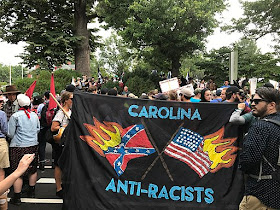 Banner reads "Carolina Anti-Racists" and shows burning Confederate battle flag and burning U.S. flag.