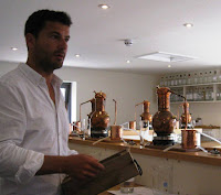 Gin school - one litre copper stills on a shelf above the workbench