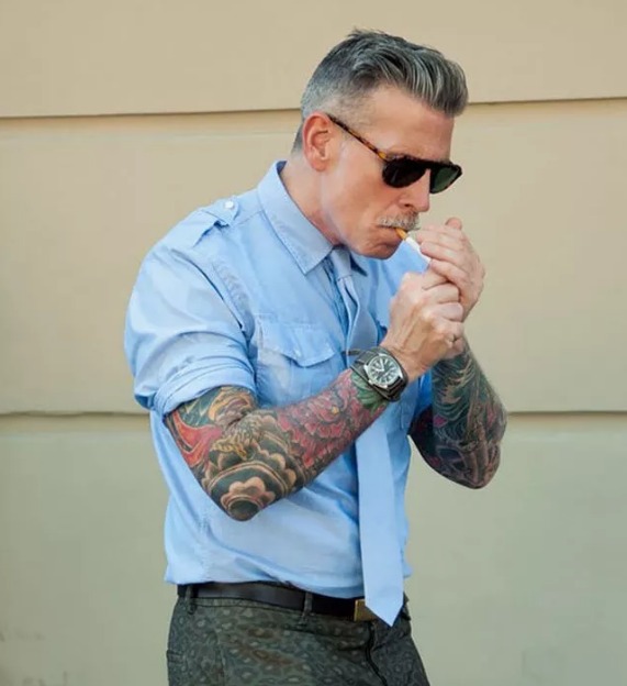 Un atractivo hombre mayor con tatuajes