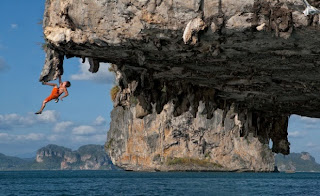 [uomo che estremamente si arrampica su una roccia, molto pericoloso]