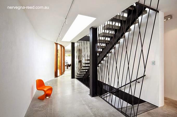 Los espacios interiores se inundan de luz natural incluso donde no hay ventanas en las paredes Sector dentro de la moderna vivienda con escalera en Melbourne, Australia