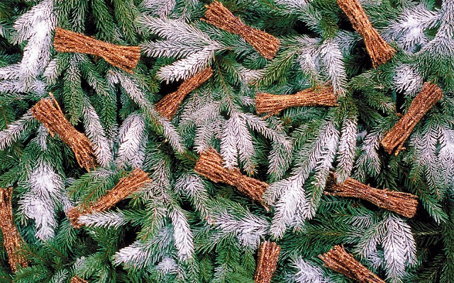 Nepsneeuw en bruine trakjes Foto van versierde kerstboom met nepsneeuw