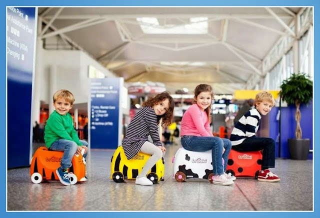 Niños montados en maletas Trunki en el aeropuerto