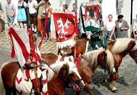 Foto vom historischen Festzug mit drei Standartenreitern