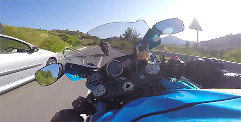 Blue motorbike racing past a car. Blue motorbike racing past a car.