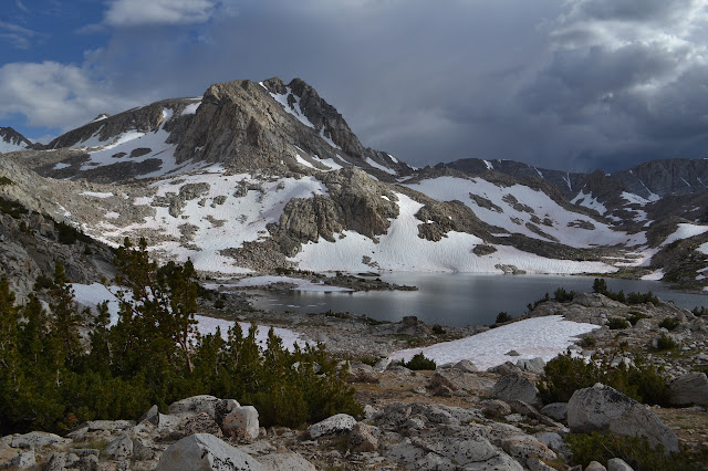 a cold lake with ice floating and a twisted peak