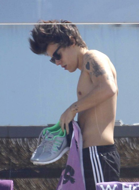 Harry Styles was spotted shirtless on the balcony of his hotel while vacati...