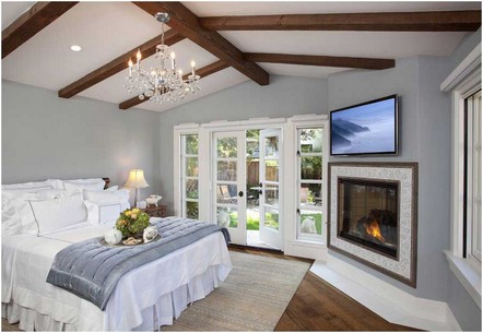 Bild-Elegantes-traditionelles-Schlafzimmer-mit-Eckkamin-und-grauen-Wänden-auch-dunkle-Hartholzfußböden-und-ein-Fliesenkamin-umgeben