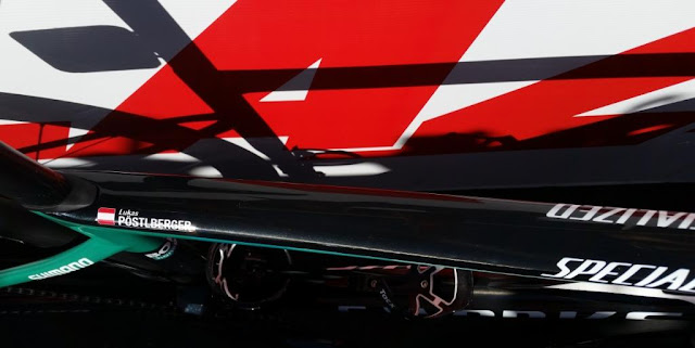 Close-up top view of Lukas Pöstlberger's racing bike with an Austrian flag and his name stamped on the cross bar. The words on the right is the bike brand Specialized.