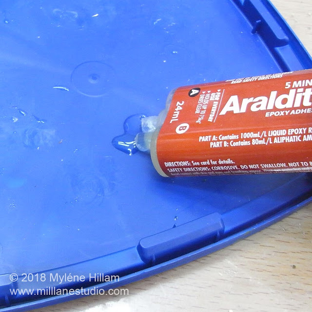 Dispensing equal parts of the 5-minute epoxy adhesive onto a plastic lid