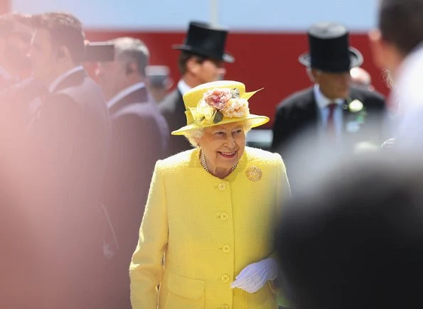 Queen Elizabeth arrived at the Epsom Derby in Surrey wearing a yellow coat, matching hat and flowery dress, holding a black bag