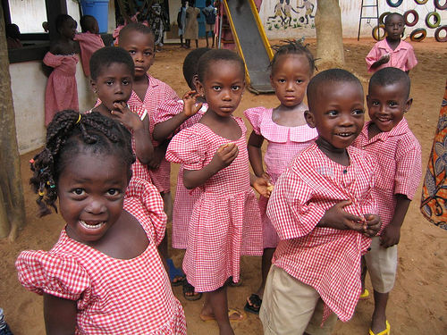 Elementary school children in Togo Africa playing games and eating snacks.