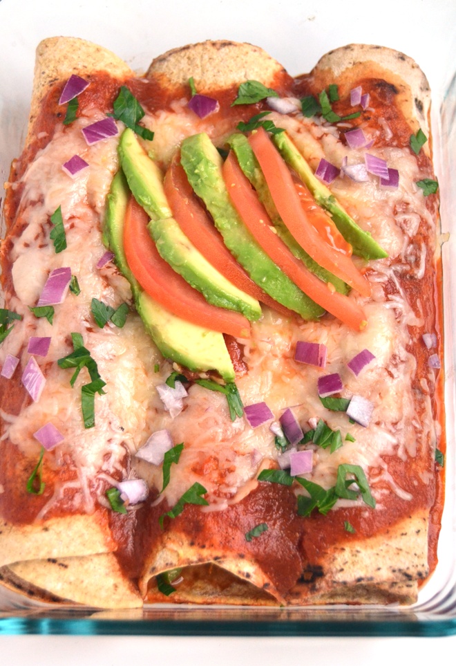 Chicken and Black Bean Enchiladas feature shredded, slow-cooker chicken, black beans, corn and bell peppers topped with a fresh, flavorful tomato sauce, melted cheese and fresh tomatoes and avocado for a meal everyone will love! www.nutritionistreviews.com