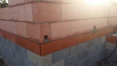 Un trou dans la brique fait en bas de chaque angle permet d’évacuer le mortier qui tombe dans la journée en prévision du coulage des poteaux d’angle et de la ceinture