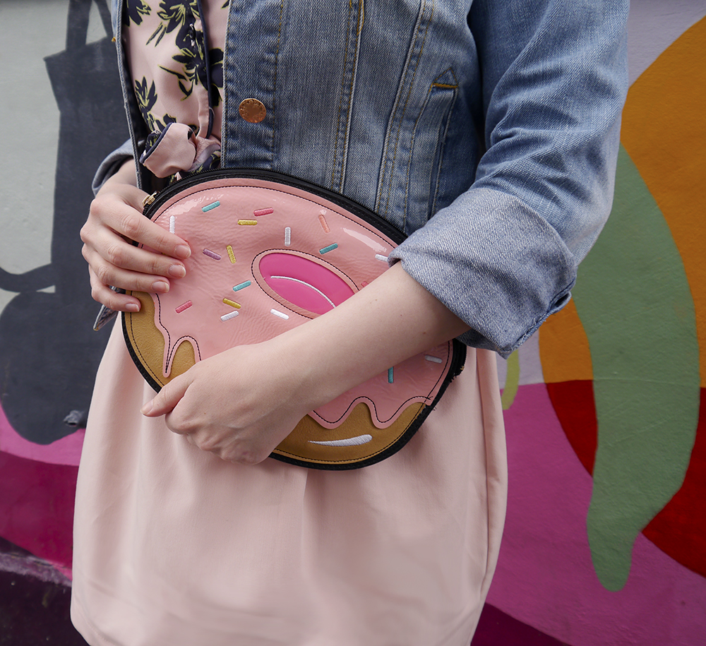 Novelty donut bag as worn by top Scottish fashion blogger Wardrobe Conversations fashion blogger wears trend of novelty bag with a donut shaped bag from New Look against a grafitti wall in Edinburgh