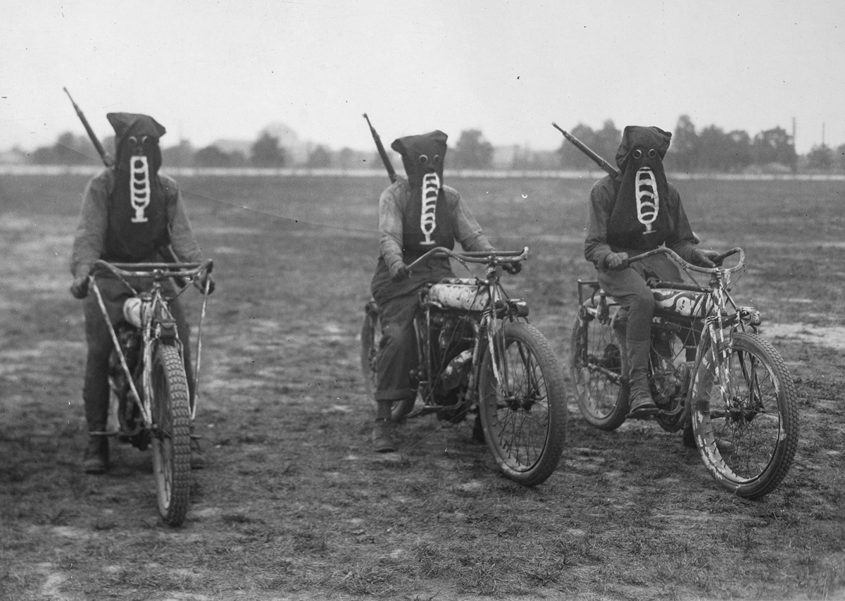 Original caption: Three motorcycle dispatch bearers in training at the U.S. Training Detachment School in Richmond, Virginia, wearing their gas masks, ready to start on a dispatch carrying trip in an exhibition.