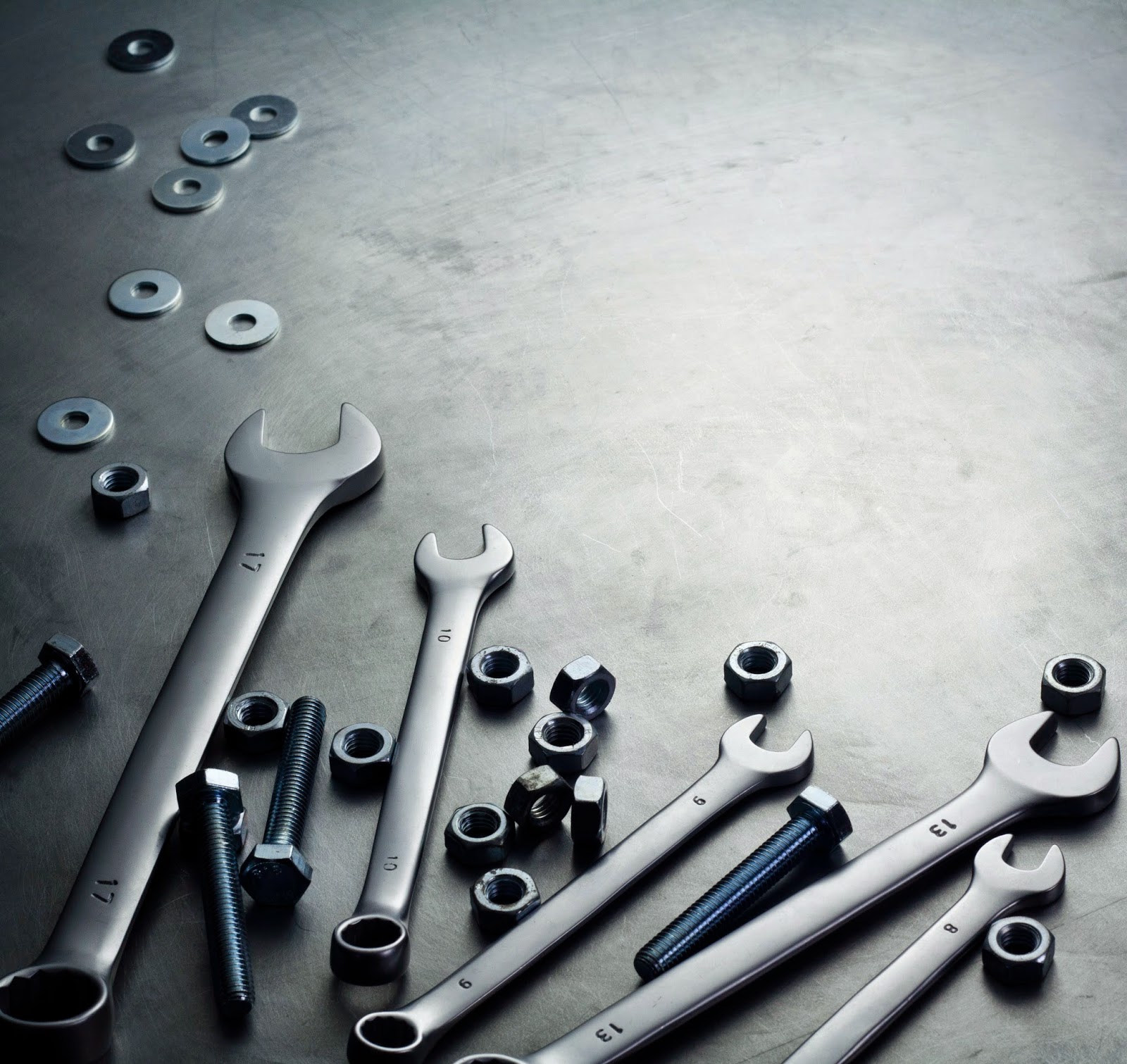 Wrenches and hardware on metal surface