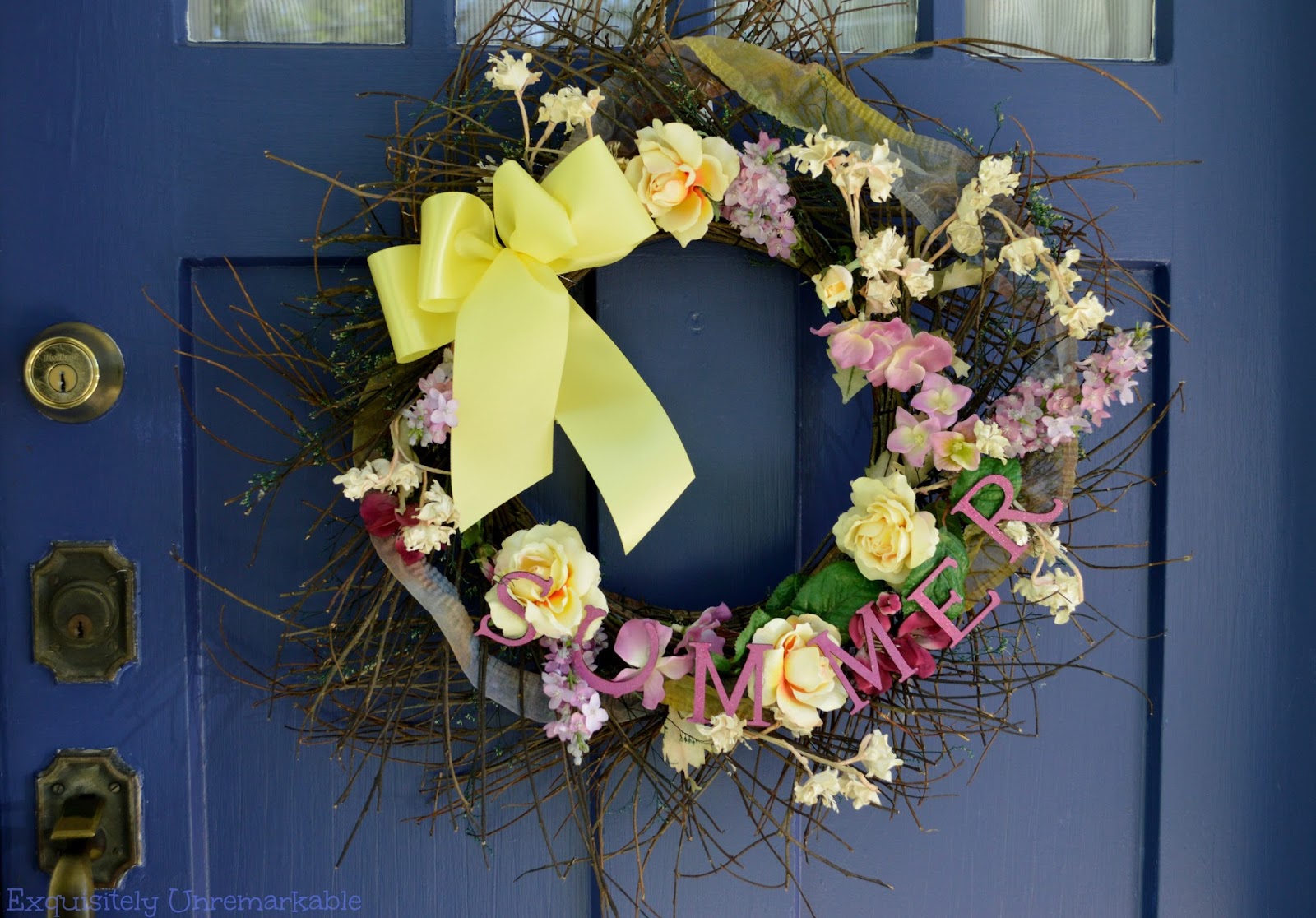 Colorful Summer Floral Wreath hanging on a blue front door