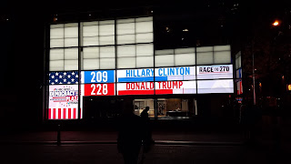 A sign showing Hillary with 209 electoral votes and Donald with 228 electoral votes