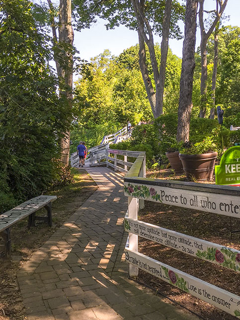 Along the Lake Geneva Lake Shore Path in Lake Geneva Wisconsin brick paved trail along a painted fence