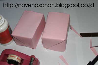 cara mudah membuat prakarya kotak pensil dari stik es krim dan bungkus teh celup bungkus terlebih dahulu kedua kotak kemasan teh celup sehingga semua gambar yang bacaan tertutup. usahakan membungkus dengan rapi terutama pada bagian sudut-sudut kotak teh celup