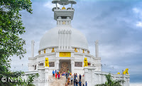 This beautiful Shanti Stupa is located around Dhauli which is on the banks of Daya river and place is about 8 km away from Bhubaneshwar. There are lot of stories associated with Dhauli Hills and how Ashoka is connected with this region. Dhauli has more to offer apart from this Shanti Stupa.This white peace pagoda is built by Japan Buddha Sangha and Kalinga Buddha Nippon Buddha Sanga.Dhauli is near major edicts of Ashoka, which are engraved on a huge rock which is preserved. Ashoka shares about welfare of the whole worlds on this rock. There is a rock cut elephant above these edicts which is considered as earliest buddhist sculpture of Odisha.It seems that Kalinga war happened around Dhauli hills. It seems that Ashoka realized the horror of a war when he noticed red Daya river with the blood of people after battle. He built various stupas and pillars around this place.This Stupa is located on a high hill which offers great views of surroundings. And Monsoons made it special for us. Everything looked fresh and green. Cloud play made the day best for photographing this place in better way. Daya river looks amazing, especially in Monsoons.Stay tuned for more exciting Photo Journeys from Bubaneshwar, Odisha.
