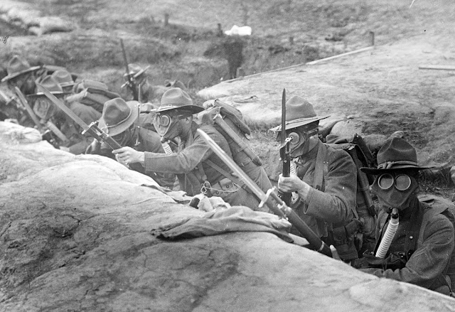 American soldiers drilling at home. Original caption: Men in the trenches with gas masks on ready to go over the top. Presidio Barracks, San Francisco, California, in June of 1918.