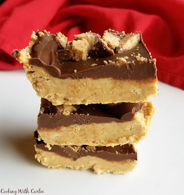 Peanut butter, graham crackers and chocolate come together in a fun no bake bar. These fun treats are sure to get rave reviews everywhere you take them. They are so easy to put together they are likely to become your new go to dessert! stack of no bake chocolate peanut butter bars with red napkin in background