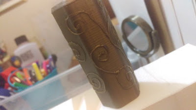 Gold PLA on the lid of a gold PLA puzzle box. Hand-drawn flourishes.