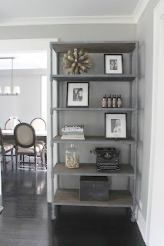 Reclaimed distressed wood etagere shelving in modern farmhouse living room on Hello Lovely Studio