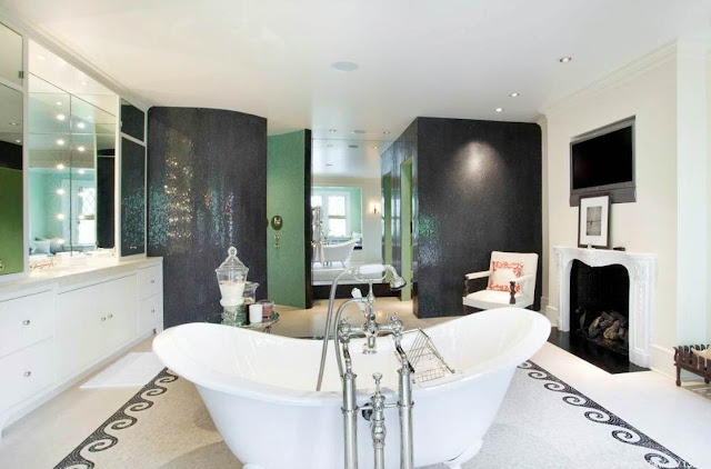 master bathroom with tile floor, stand alone tub, fireplace, green walls and a tv