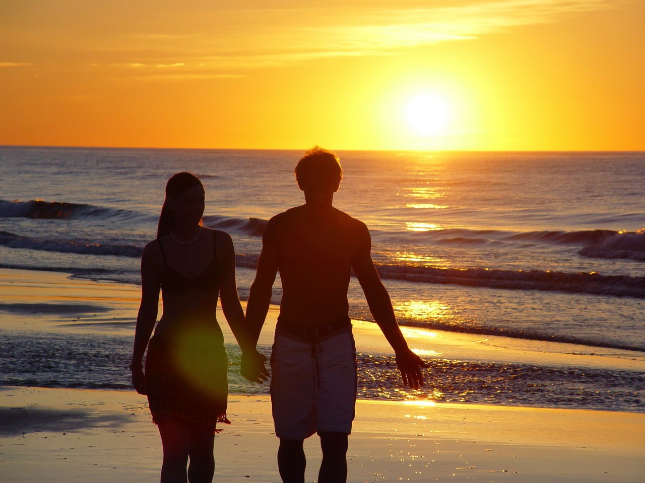 Photos of young couples are holding hands and walking on the beach