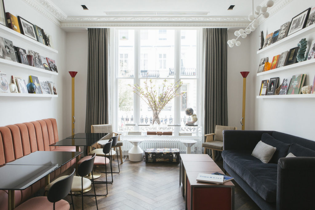 Library with books on wall shelves at The Laslett Hotel in Notting Hill in the heart of West London