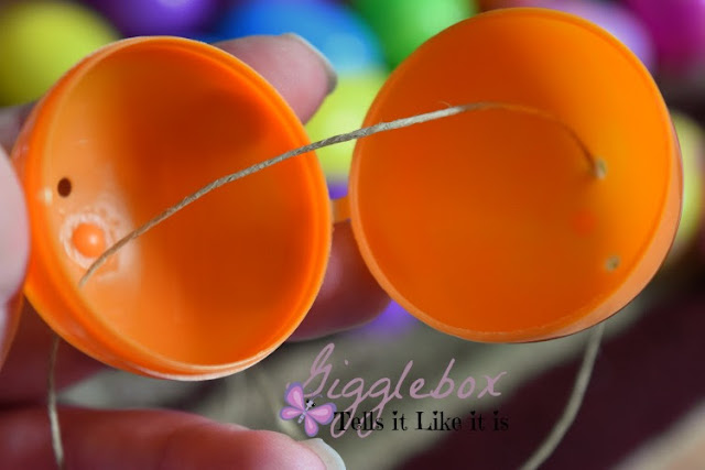 simple and cheap Easter decoration made with a gift bag plastic eggs and string, Easter decoration, cheap Easter decoration, using plastic Easter eggs for more than just egg hunts and baskets,