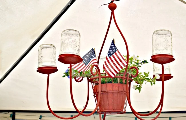 red chandelier with mason jars and a plant with flags