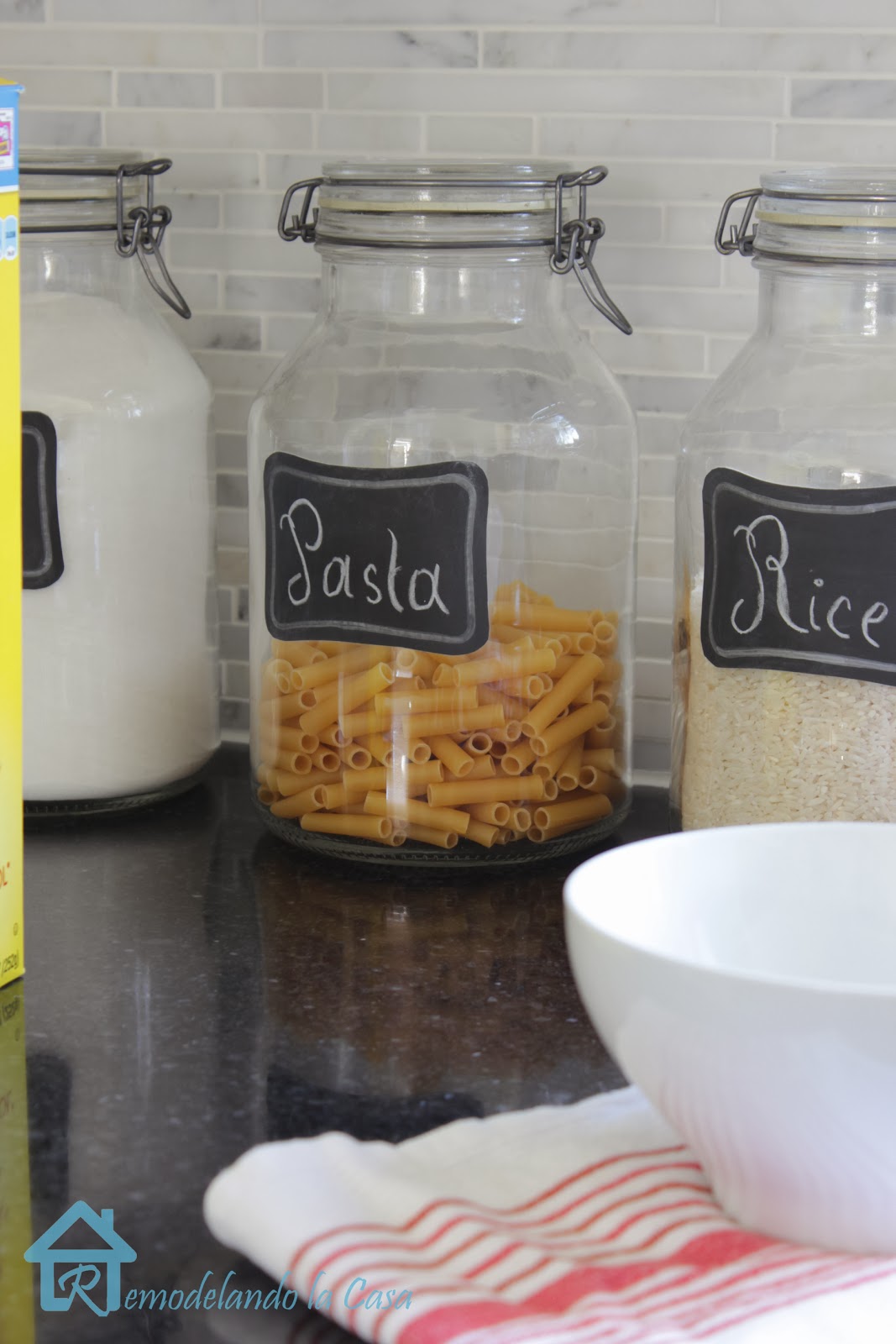 glass jars storing rice, sugar, flour on kitchen countertop
