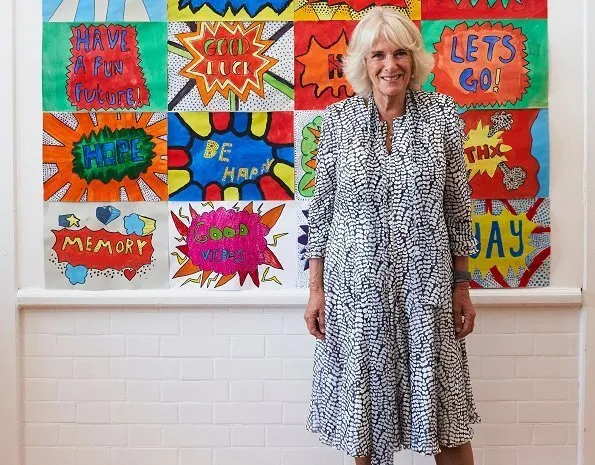 The Duchess of Cornwall is patron of The National Literacy Trust. The duchess wore a printed silk summer midi dress. beige pumps and bag