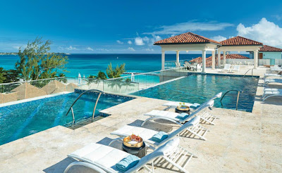 Chaise longue, bain de soleil face à la piscine débordante et vue sur la mer des Caraibes