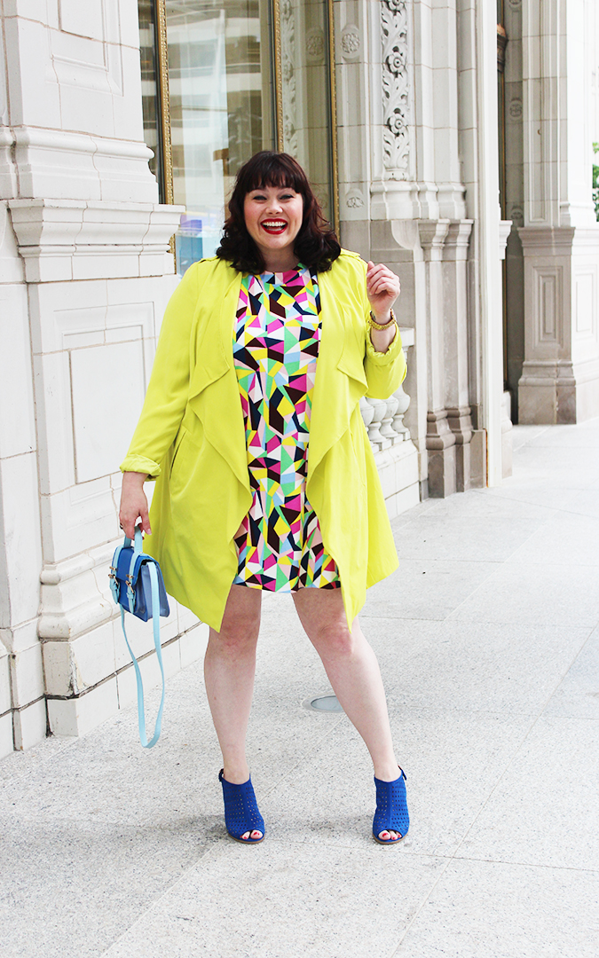 Plus Size Blogger Amber from Style Plus Curves in a Simply Be USA Colorful Abstract Dress, Bright Yellow Coat and Blue Accessories