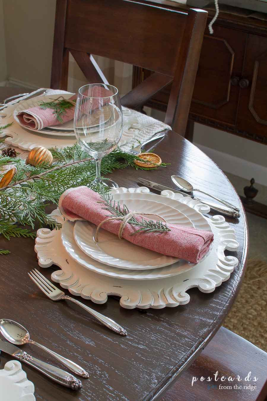 Tour a charming home filled with vintage items. So many great ideas for Christmas decorating. #Christmasdecor #homedecor Christmas place setting with white plates, linen napkins, and vintage silver