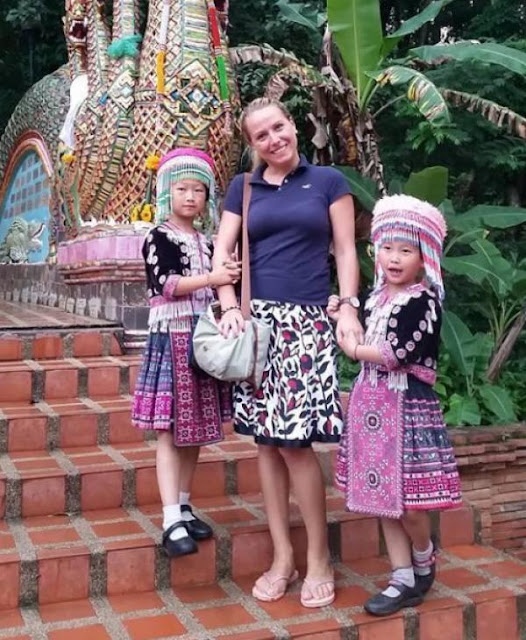 Une touriste prend la pose avec deux petites filles en costumes traditionnels: voyez-vous ce qui cloche sur cette photo?