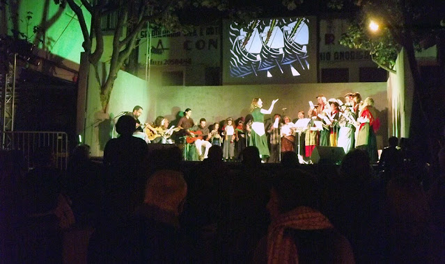Grupo folclórico um palco à noite e pessoas assistindo