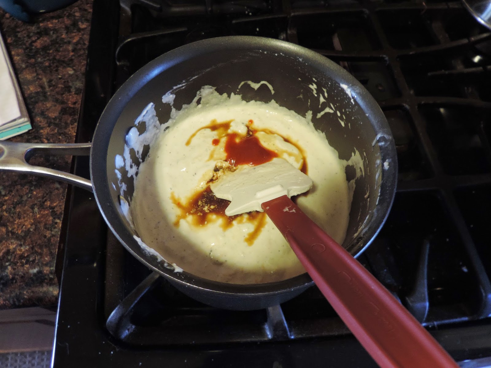 Sriracha and Worcestershire sauce being added to the cheese. 