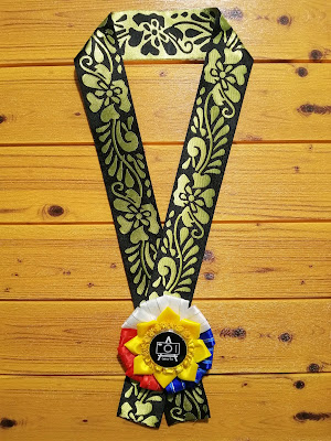 Philippine-flag inspired rosette in a black/gold brocade trimming lei Original design of Kalayan Rosette in a brocade trimming as lei