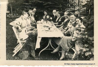 Photo noir et blanc ancienne : toute la famille réunie autour de la table même le chien Photo noir et blanc ancienne : toute la famille réunie autour de la table même le chien
