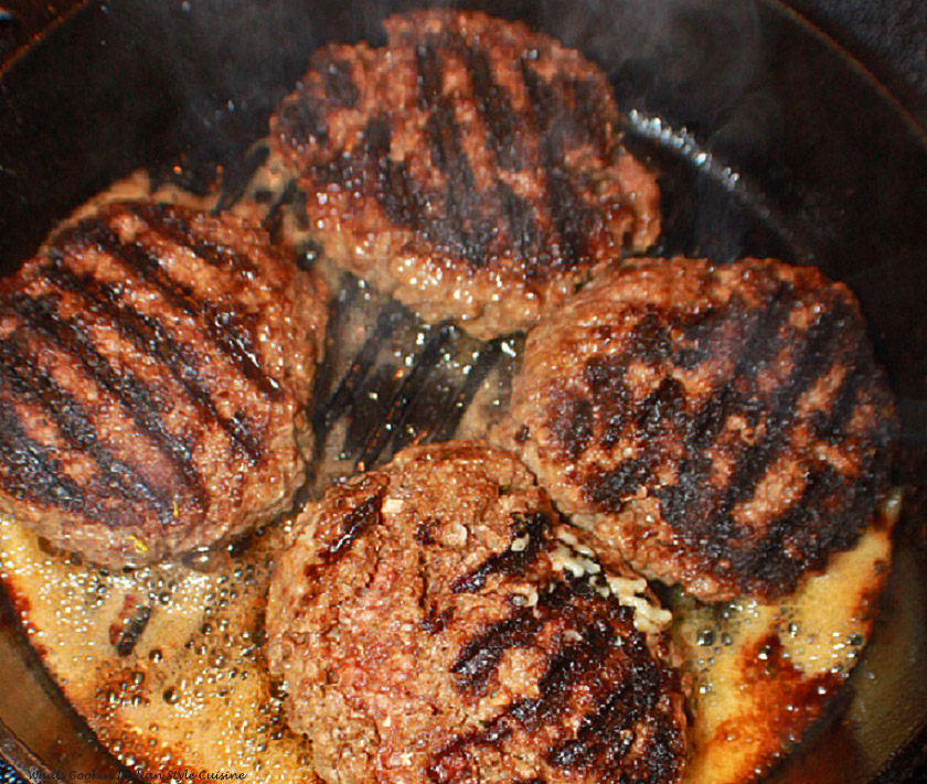 These are four hamburgers mixed into Parmesan and garlic mixture and molded into 4 patties in a cast iron skillet getting ready to be grilled