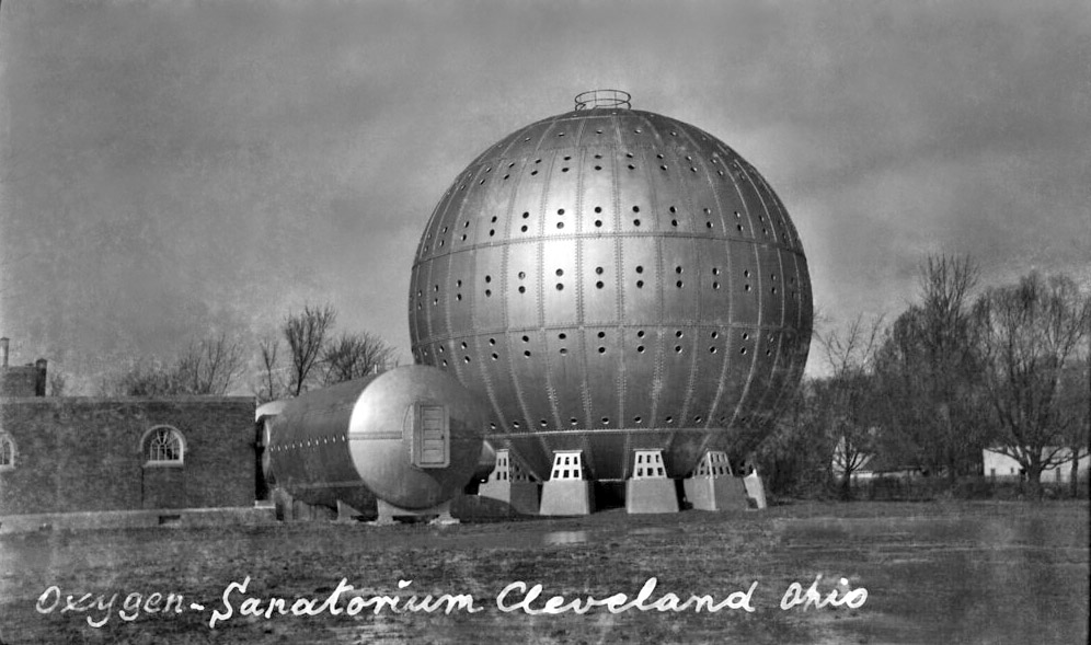 Foto en blanc i negre de l’esfera d’acer amb la llegenda escrita a mà “Oxygen-Sanatorium Cleveland Ohio”