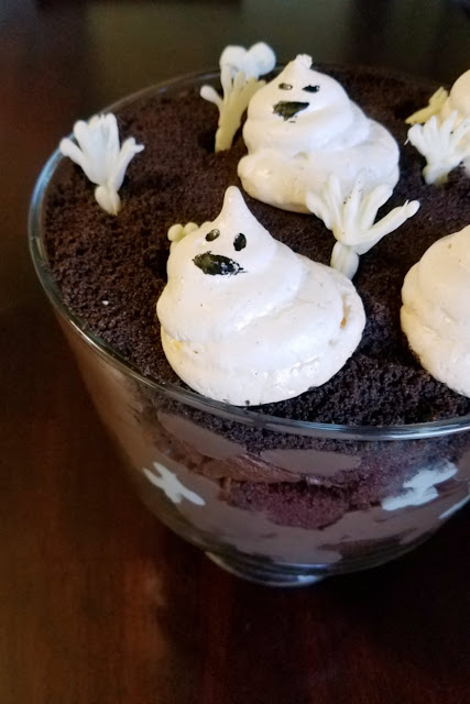 So sweet and so spooooooky! This trifle is full of chocolate goodness with sweet meringue ghosts and white chocolate bones. It's a great Halloween treat! close up of ghosts on top of chocolate trifle