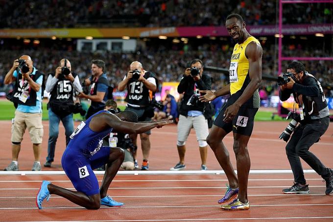 World champion Justin Gatlin (on his knees) paying homage to Usain Bolt after stunning the retiring Jamaican to win the 100m final at the World Championships in London yesterday morning.