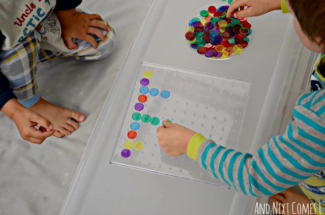 Kids making colorful math patterns on a clear geoboard